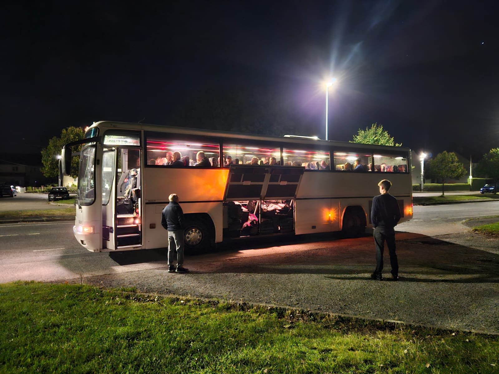 Passengers boarding a Paynes coach at night