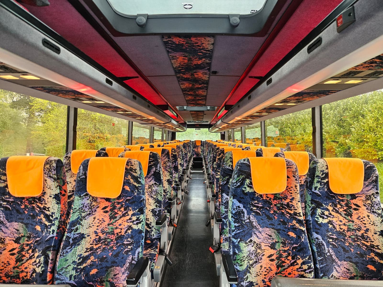 Large Volvo coach front view with trees